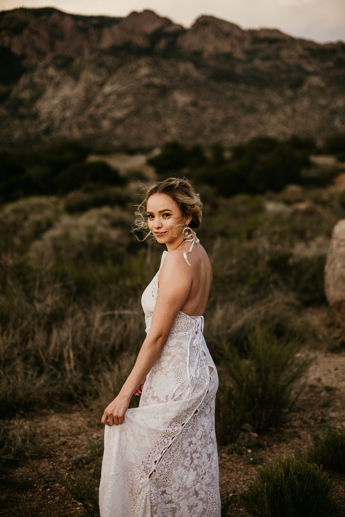 bride holding dress in New Mexico desert