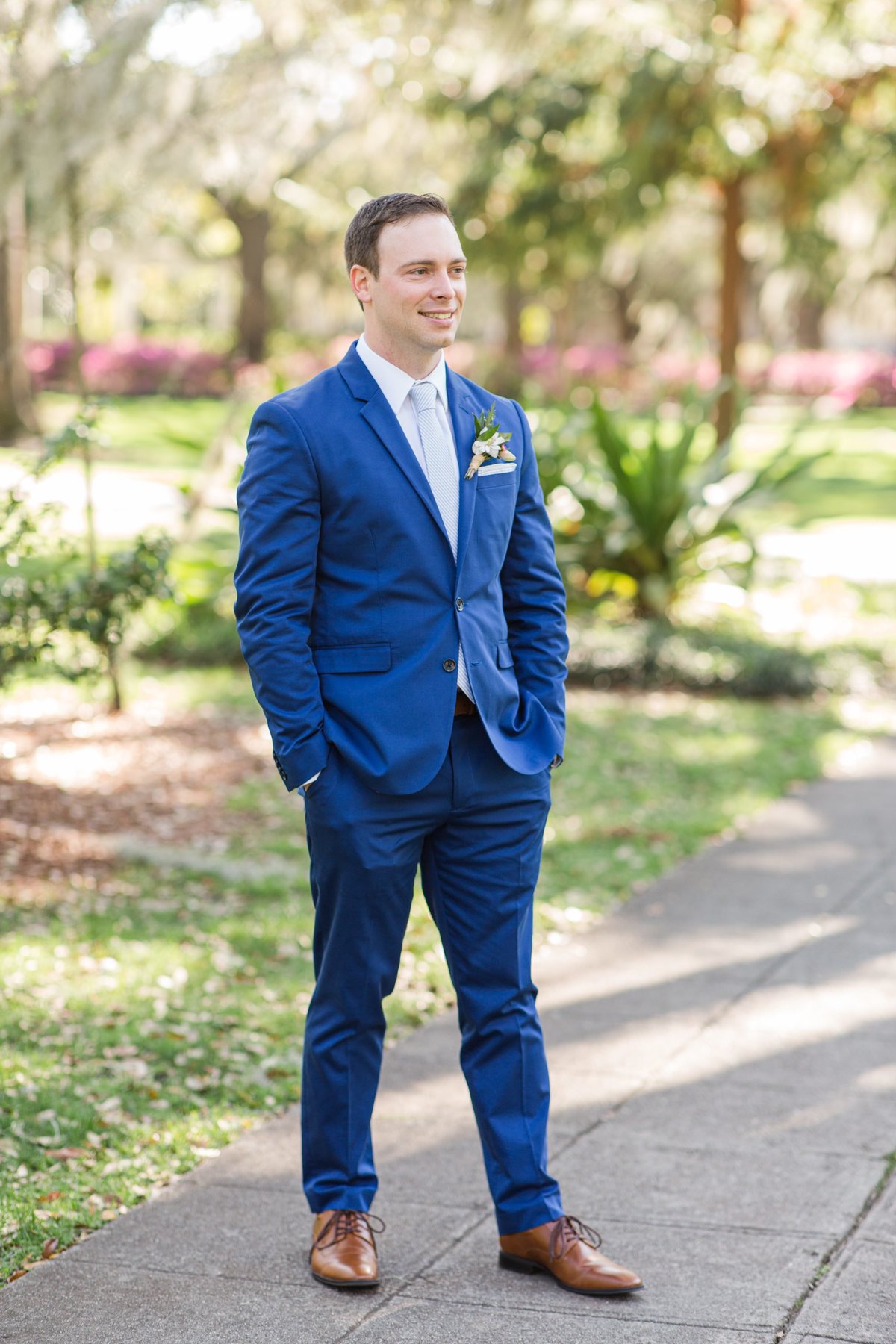 groom satanding alone in blue suit