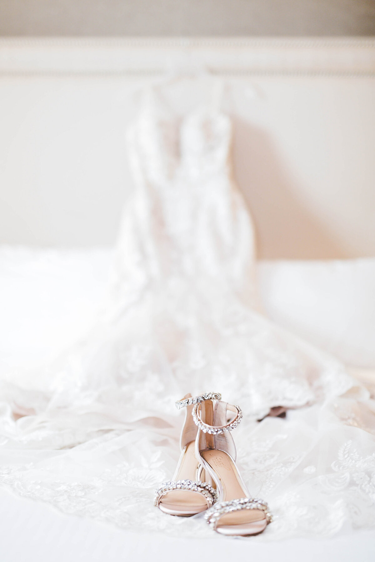 beautiful wedding dress and wedding shoes laid out on a bed