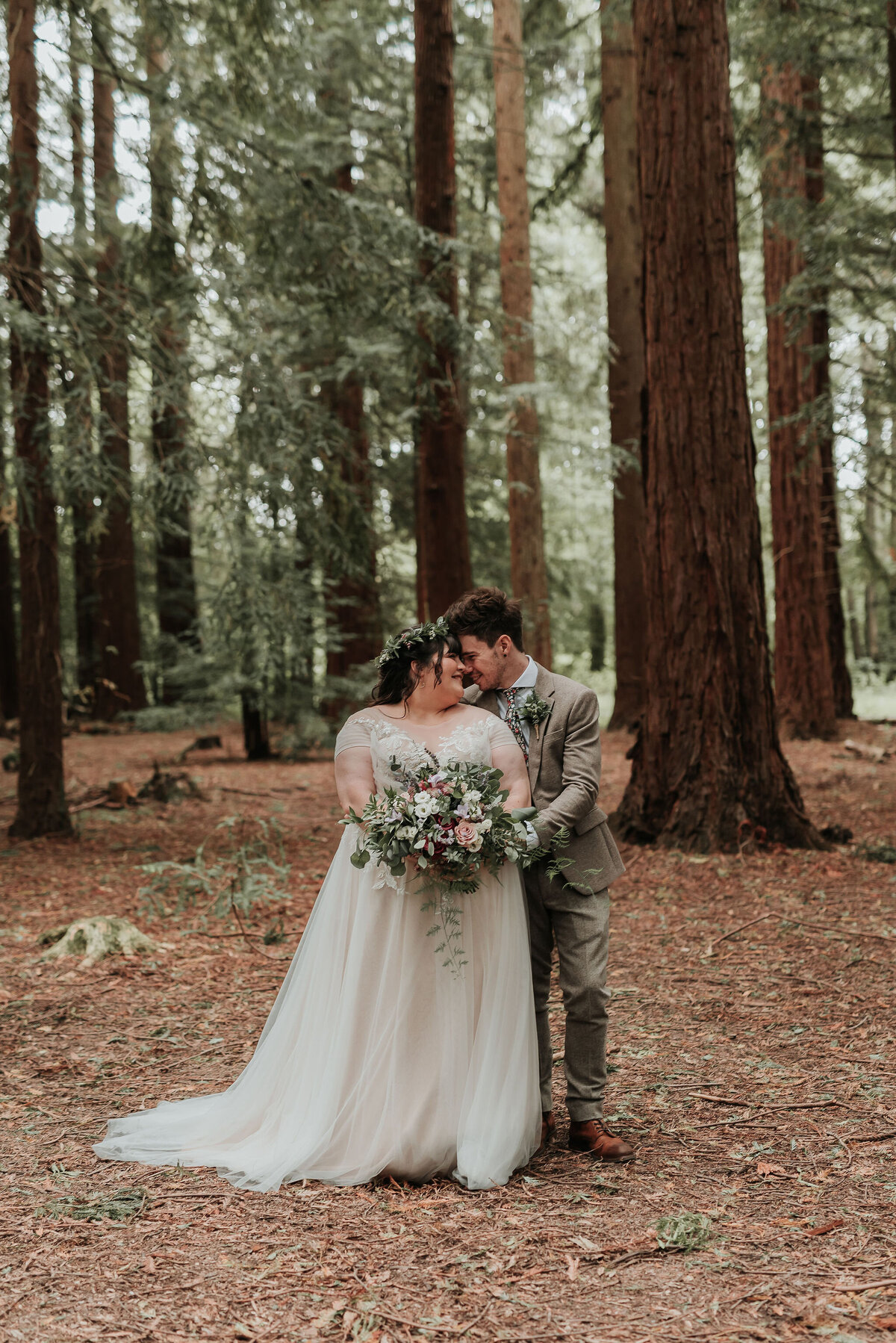 Bride & Groom embrace gently in the woodlands at their romantic woodland wedding at Two Woods Estate