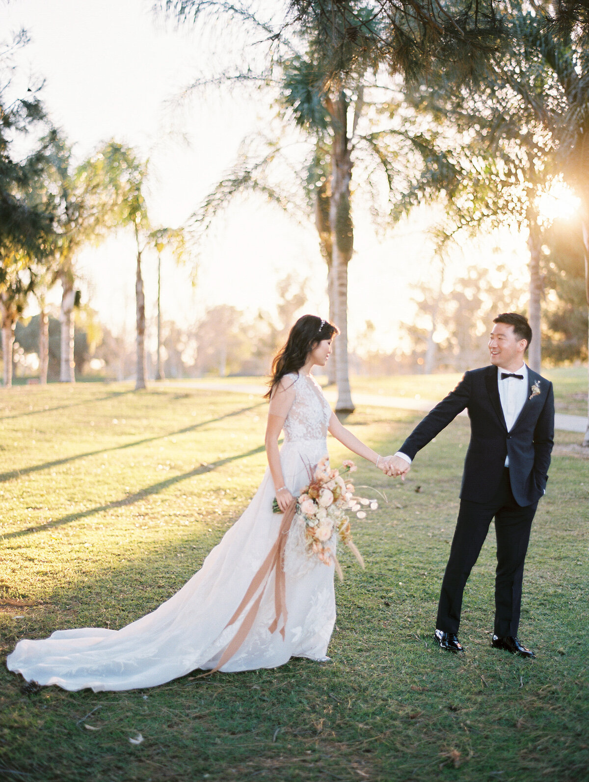 bride and groom walking at sunset