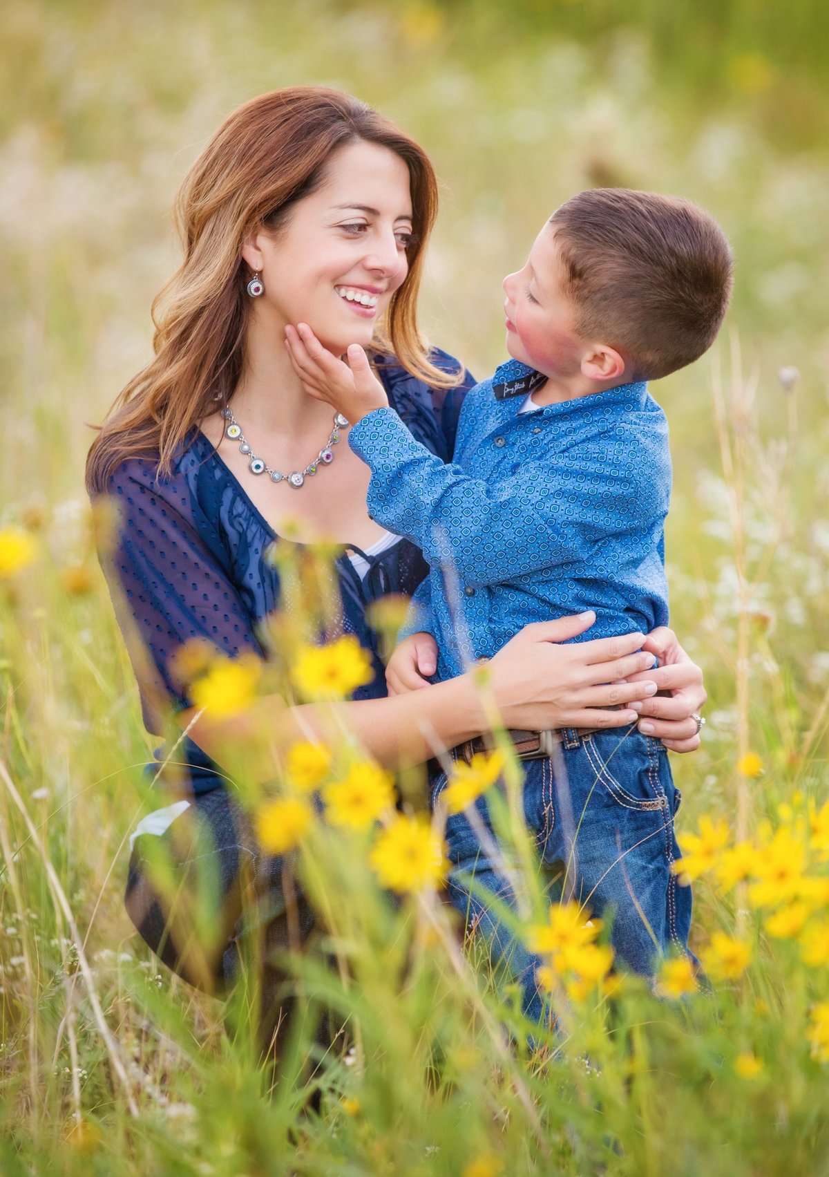 A mother embracing  her small son in a Laramie field with yellow flowers