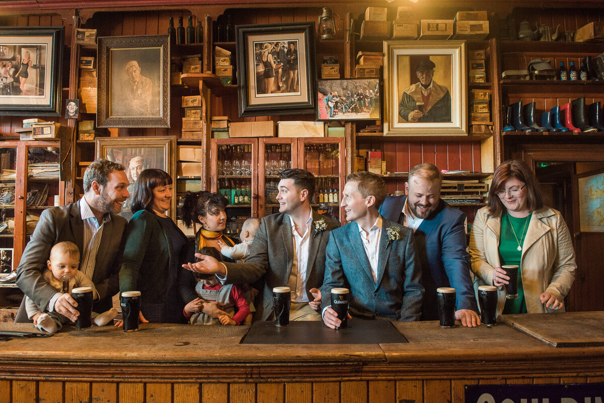 Grooms in traditional Irish pub having fun with guests