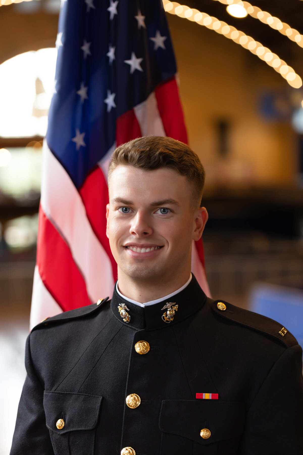 Marine officer senior portrait in Dahlgren Hall with an American flag in Annapolis, Maryland.