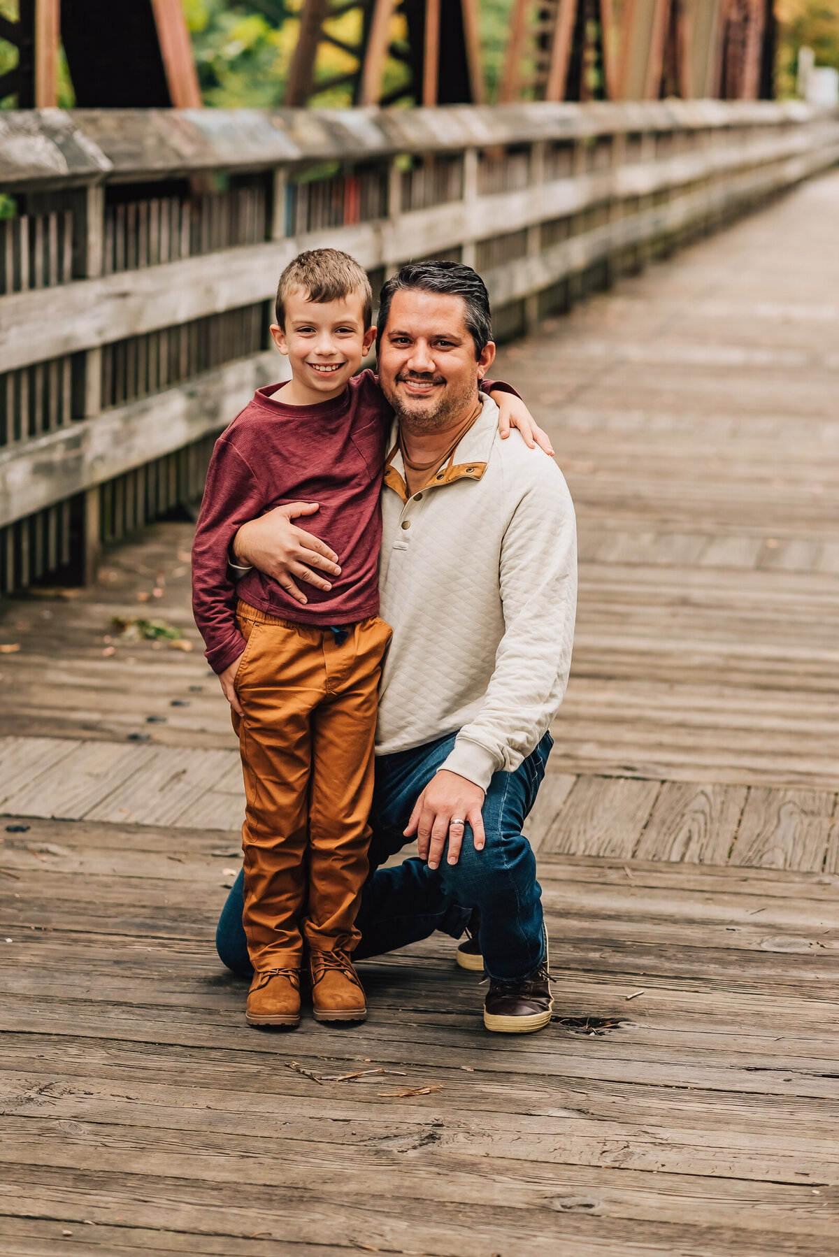 A father smiling at the camera with his young son at their family session in Canton, CT.