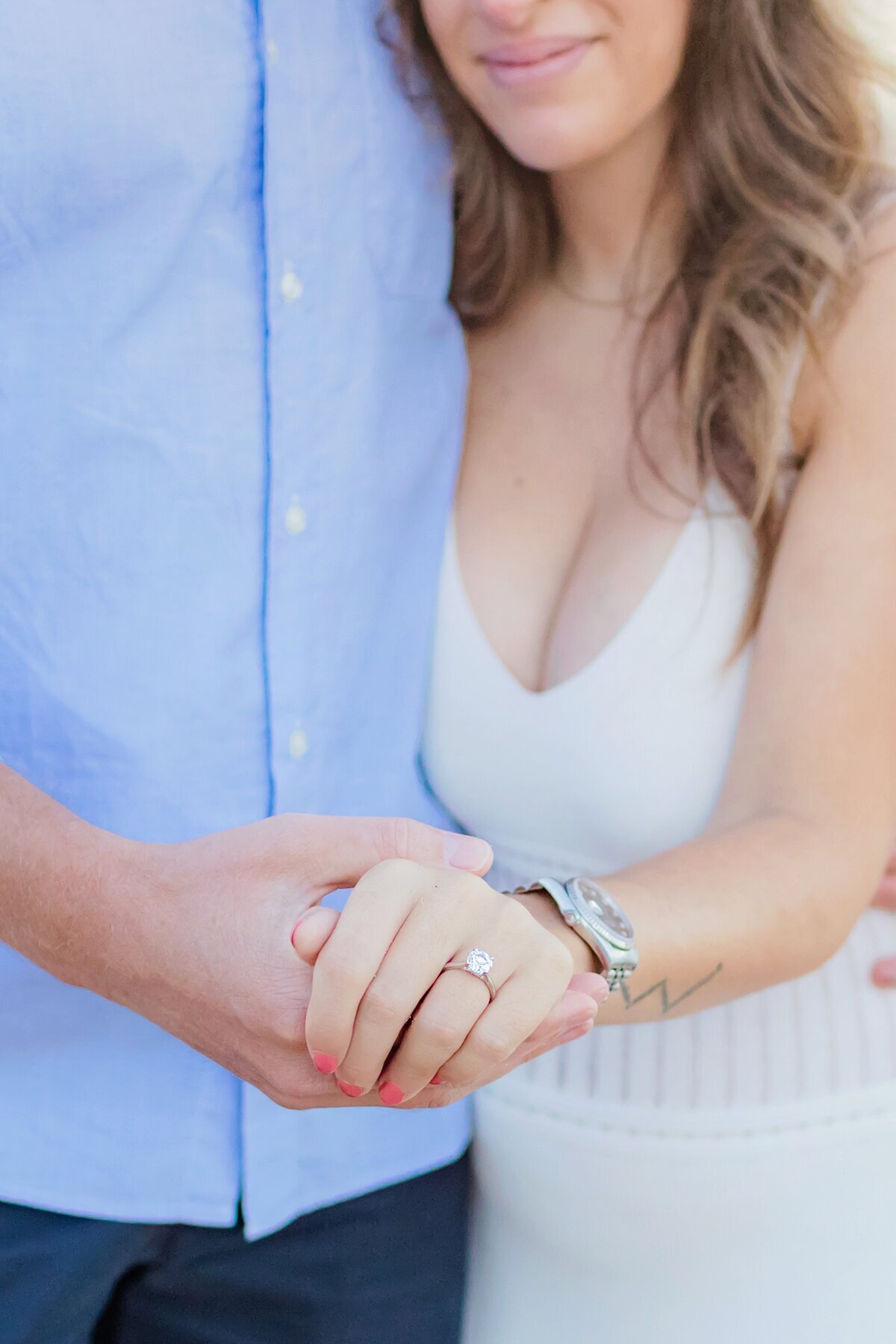 Woman in a white dress shows off her engagement ring during her surprise Wailea proposal photoshoot