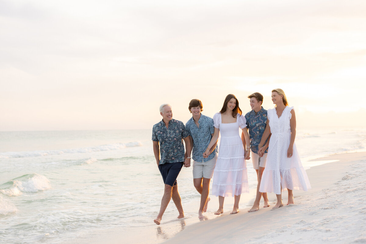 A family holding hands and walking together along the beach