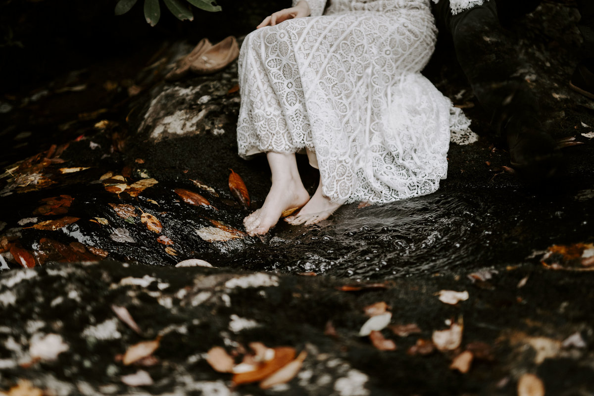 Bride barefoot in a pool of water during adventure elopement in Asheville