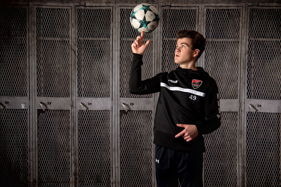 senior photo with senior boy and soccer ball on locker background