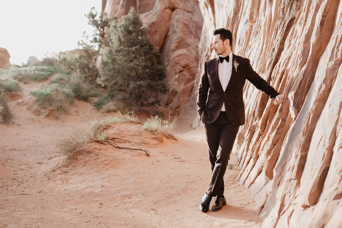 Utah elopement photographer captures groom standing with feet crossed
