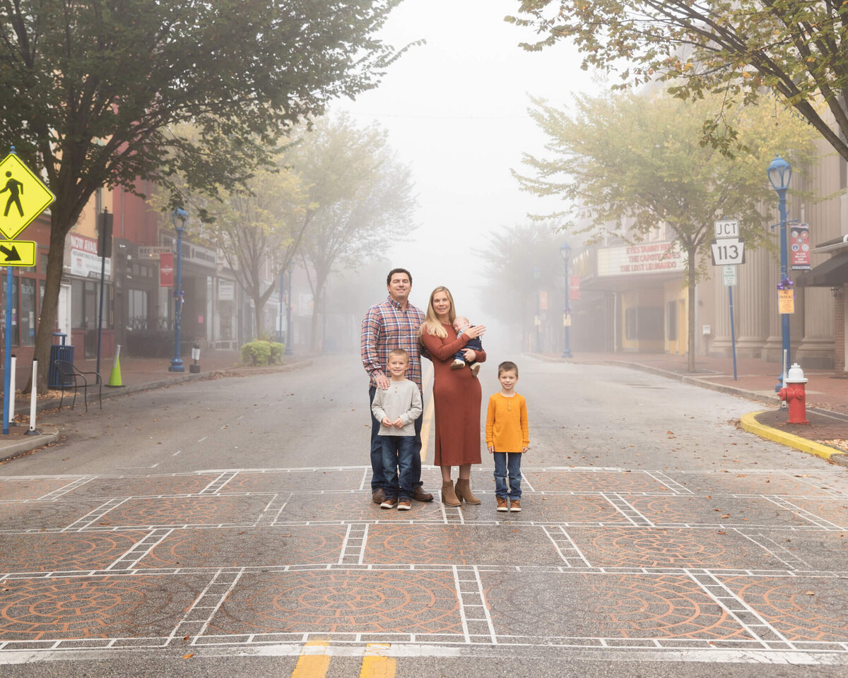 Family of 5 standing in a  street with fog surrounding them