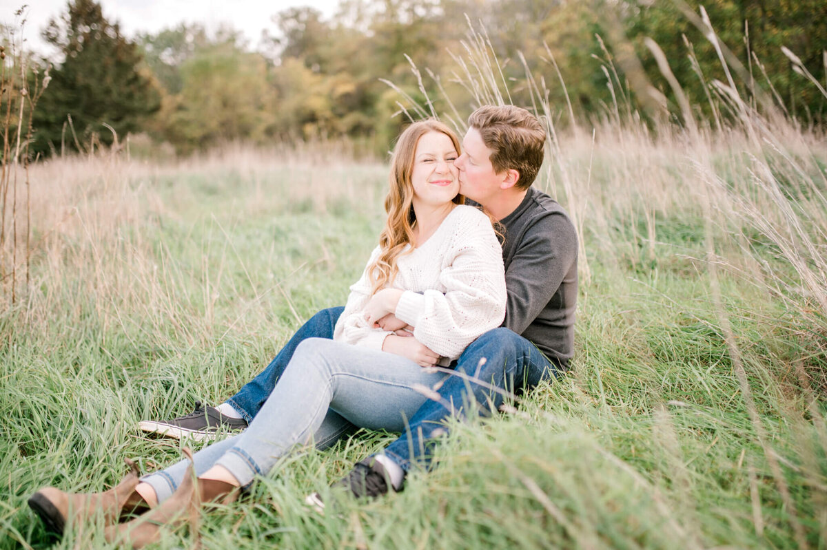 Niagara Wedding Photographer Kristine Marie captures photo of  engaged couple nestled in tall grass
