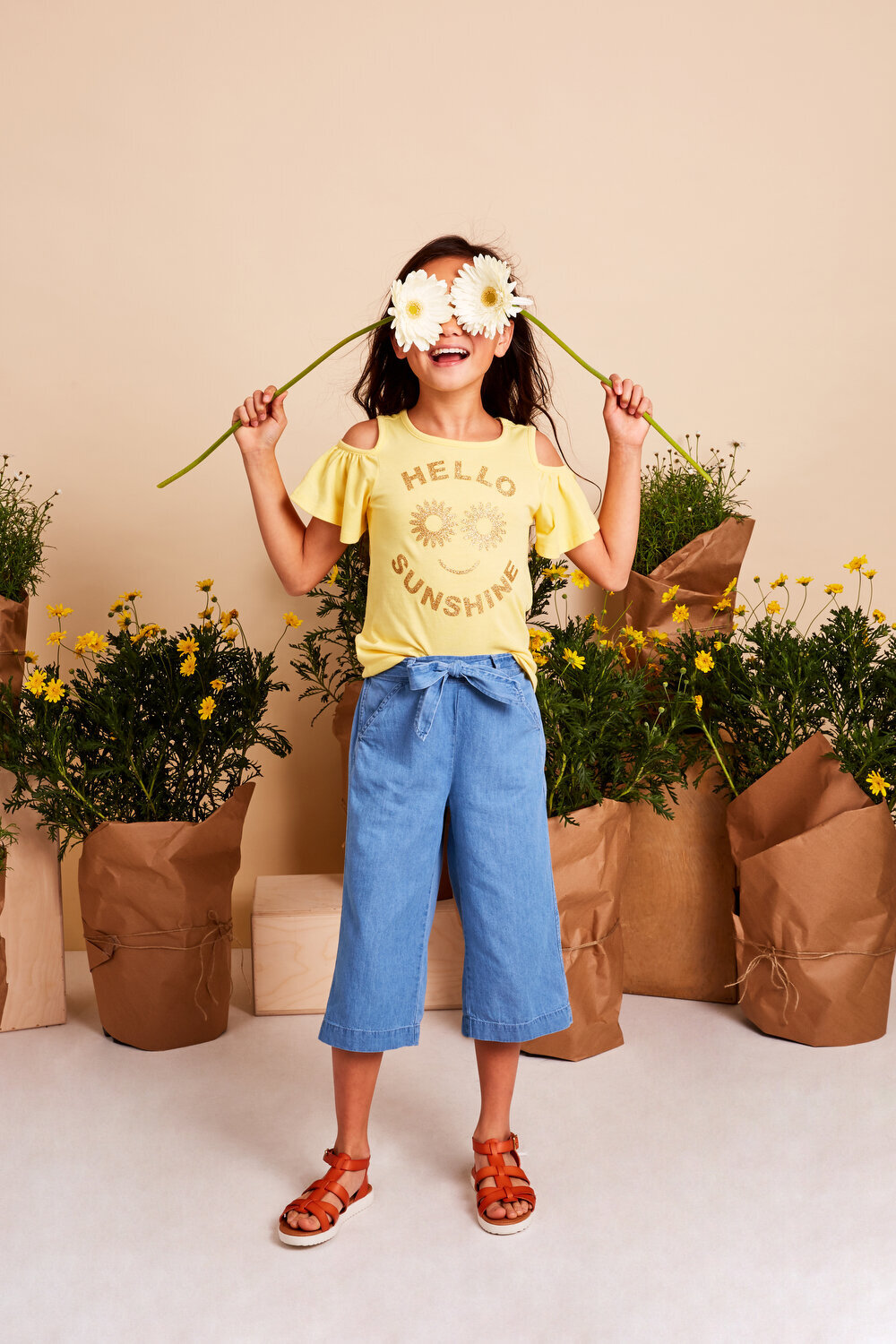 Greer Rivera Photography Kids Editorial Photoshoots Marin CA Girl Holding Daisies in front of her eyes with plants in the background