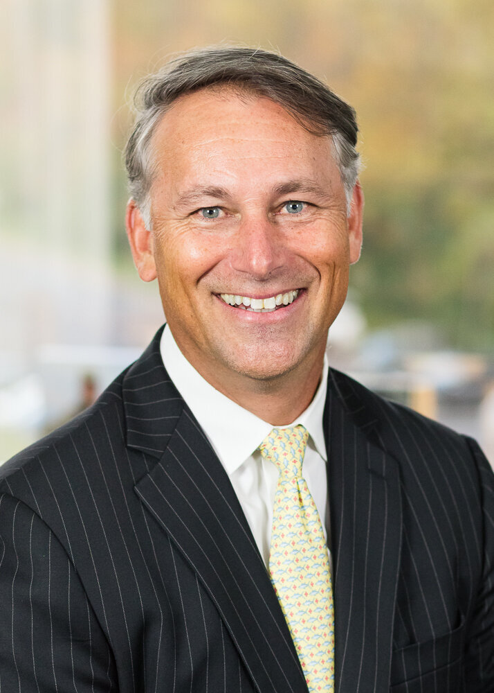 Business headshot of a company CEO wearing suit and tie.