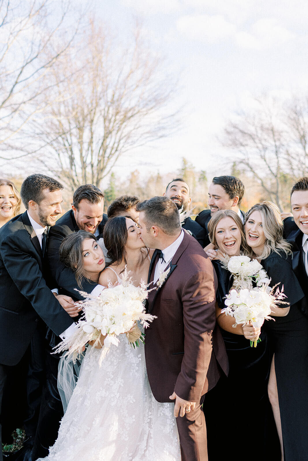 bride-and-groom-kiss-in-front-of-wedding-party