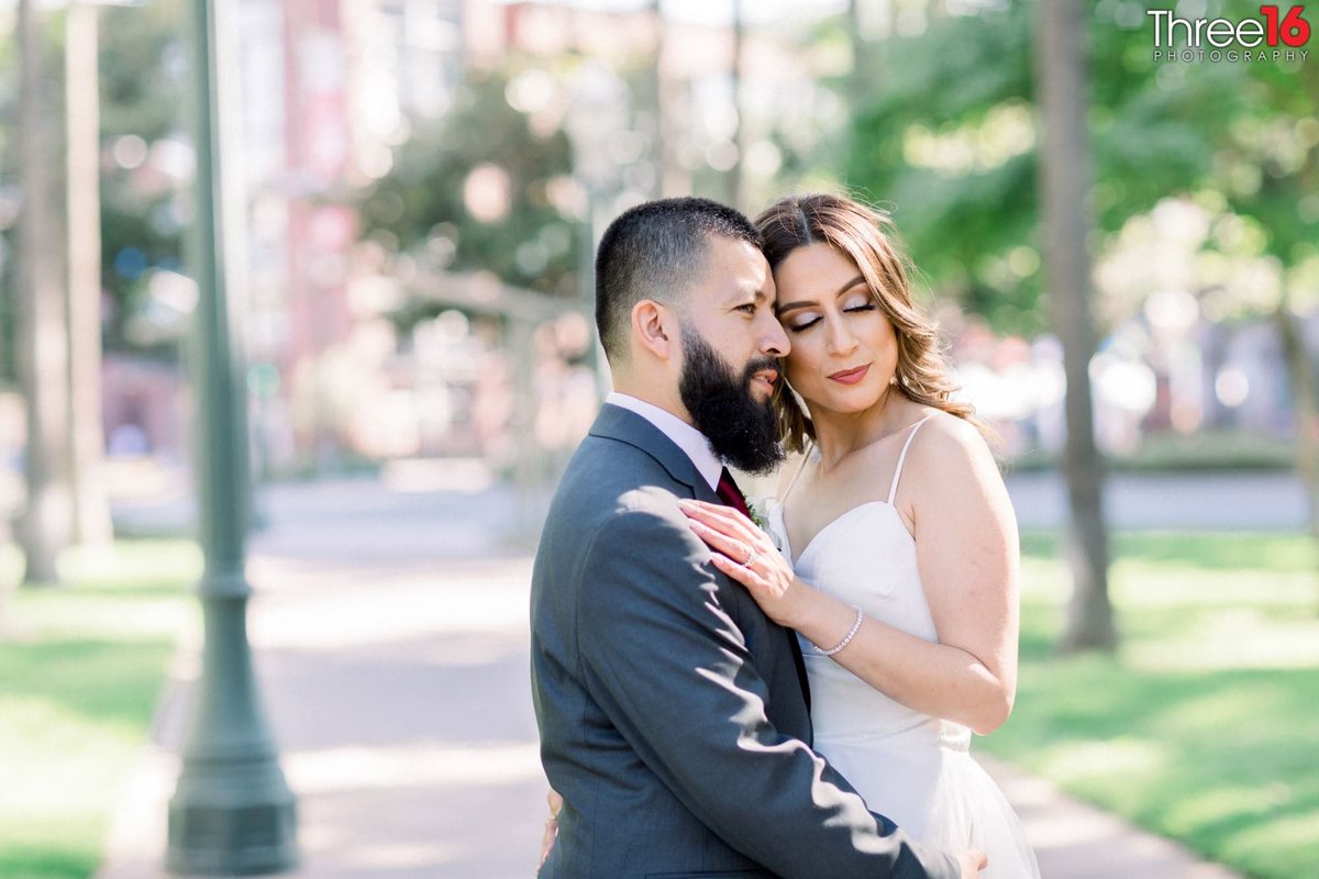Bride and Groom snuggle up as they embrace each other during photo session