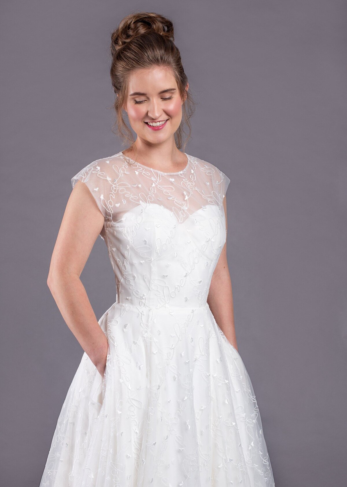 The strapless corseted foundation of the Norma Jean bridal style sits under the embroidered high-neck illusion bodice.
