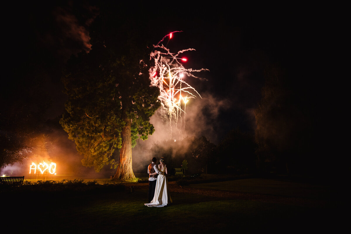 Bride and groom watching fireworks at stapleford park wedding