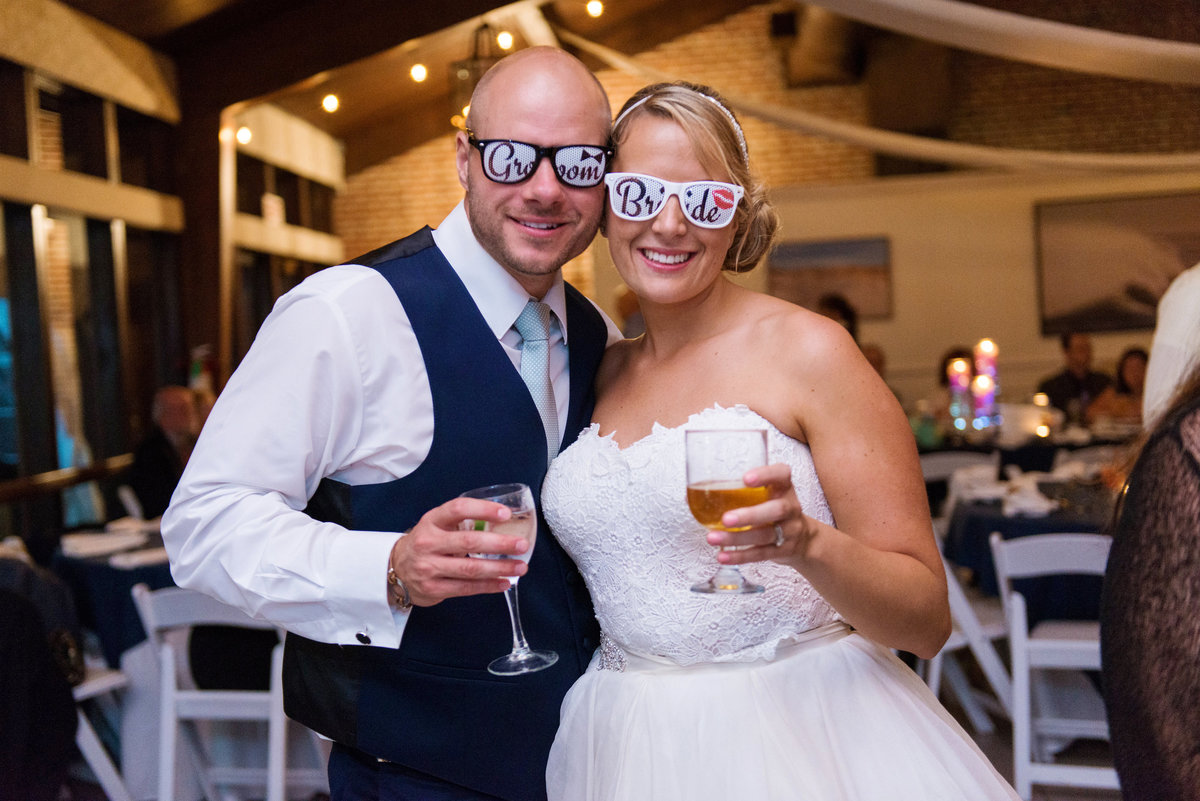 bride and groom with drinks and sunglasses during wedding reception at Pavilion at Sunken Meadow