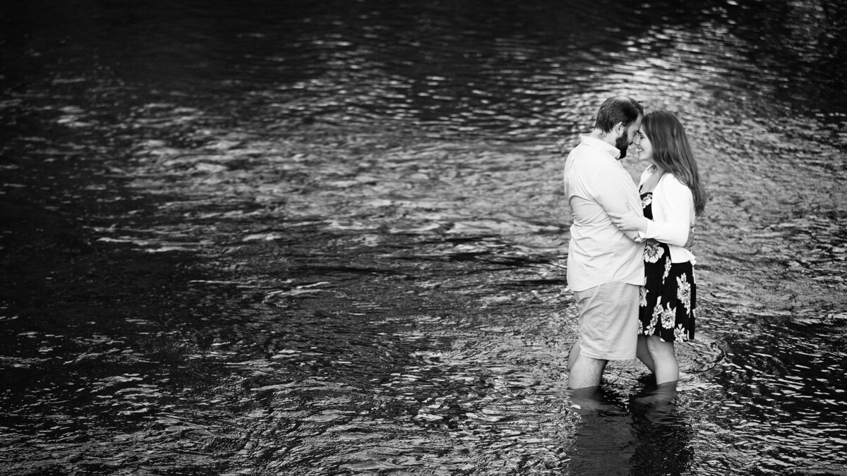 A romantic engagement portrait in shallow water river.