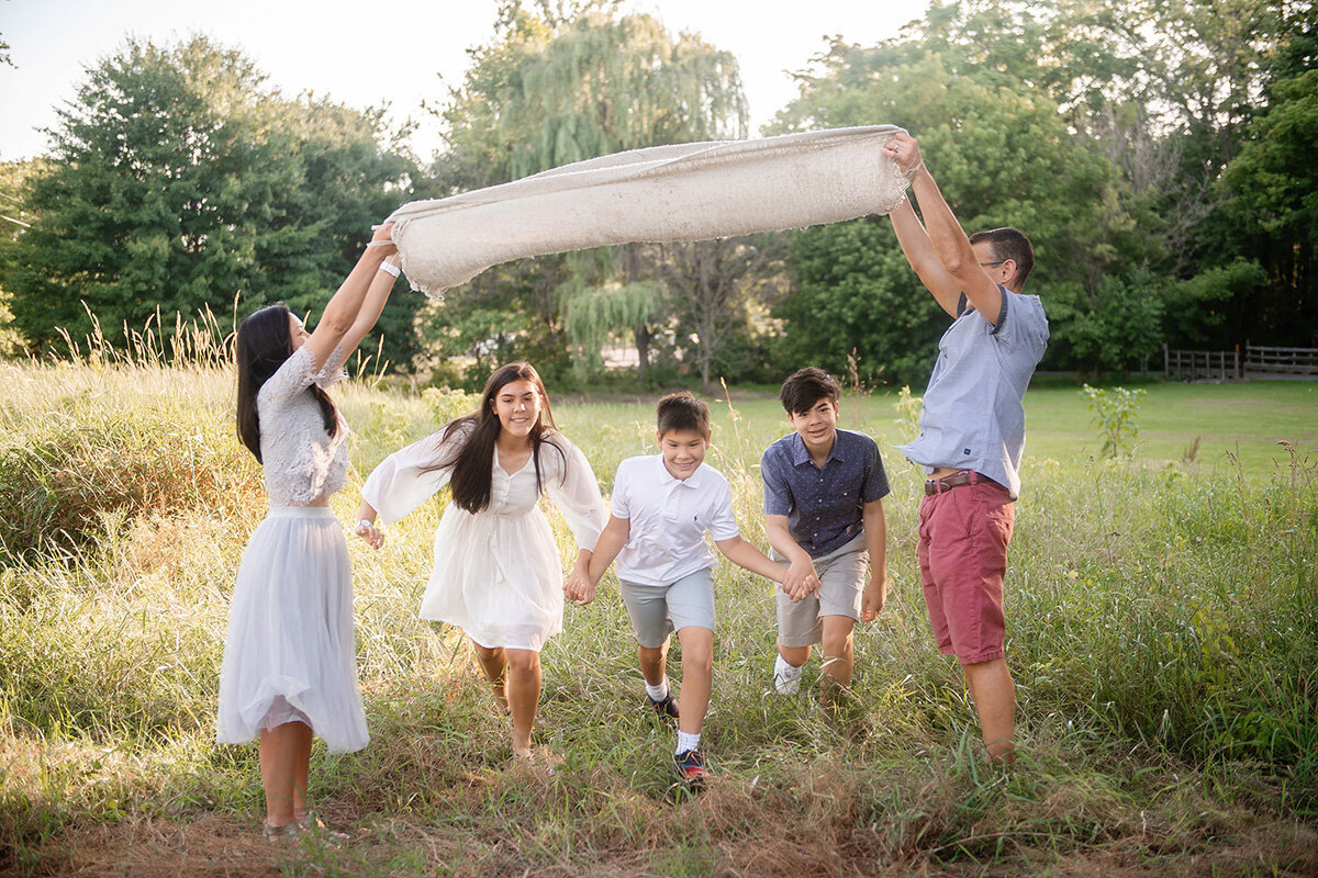 Children running under a blanket family session