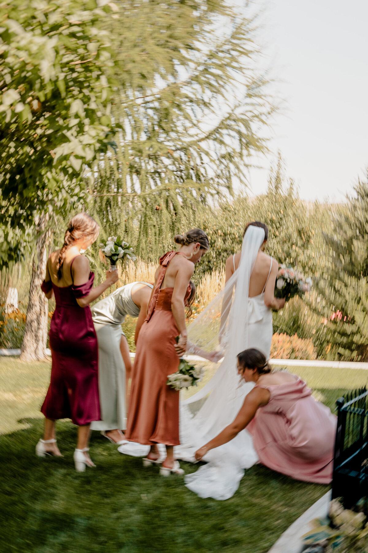 The bridesmaids help the bride adjust her train at The Barn on Hinman in Cashmere, Washington.
