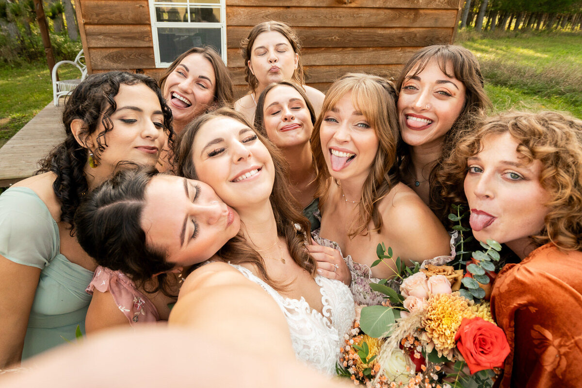 Bride does a selfie with all her bridesmaids on her wedding day.