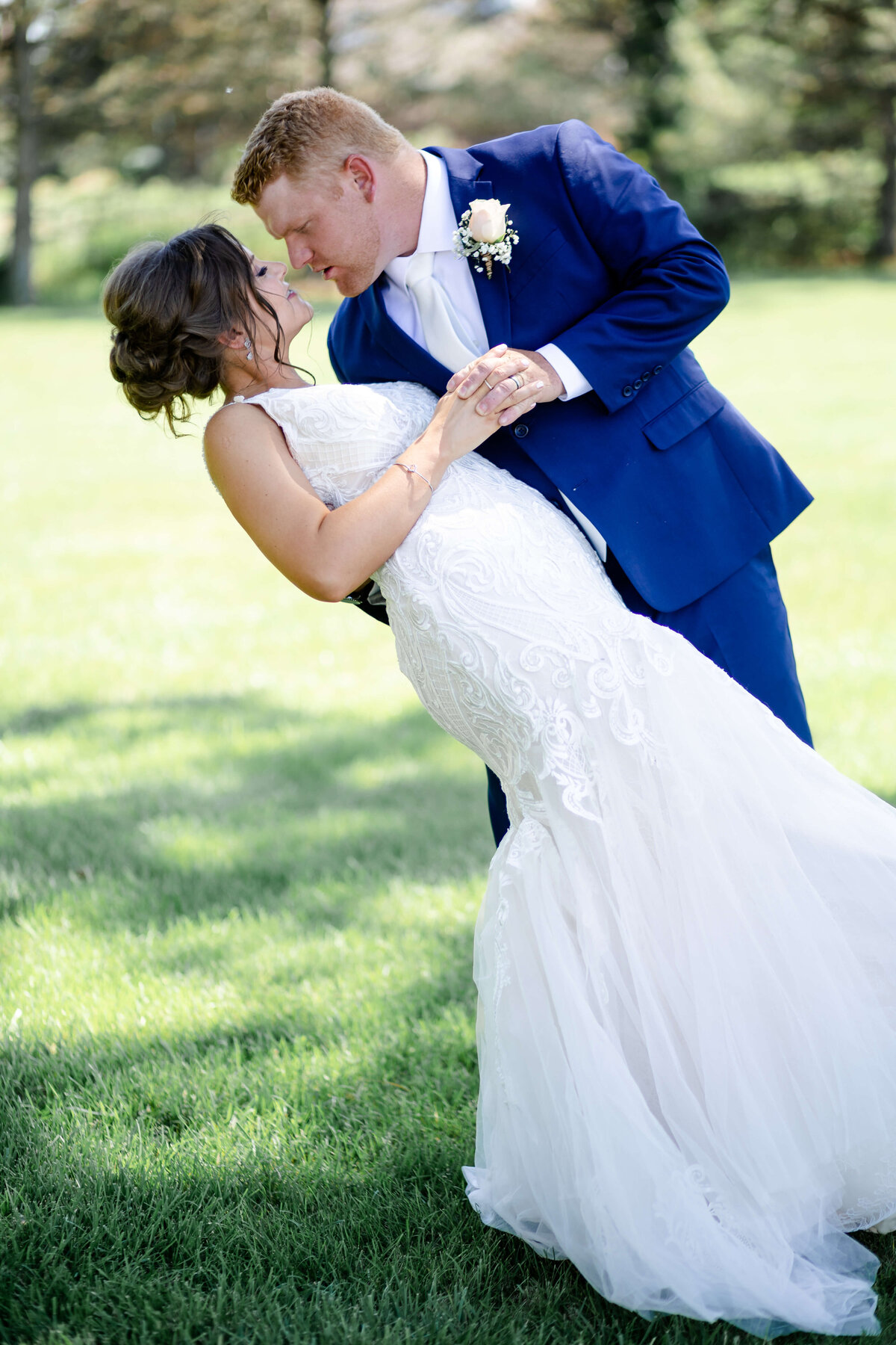 husband dipping wife outside after beautiful wedding