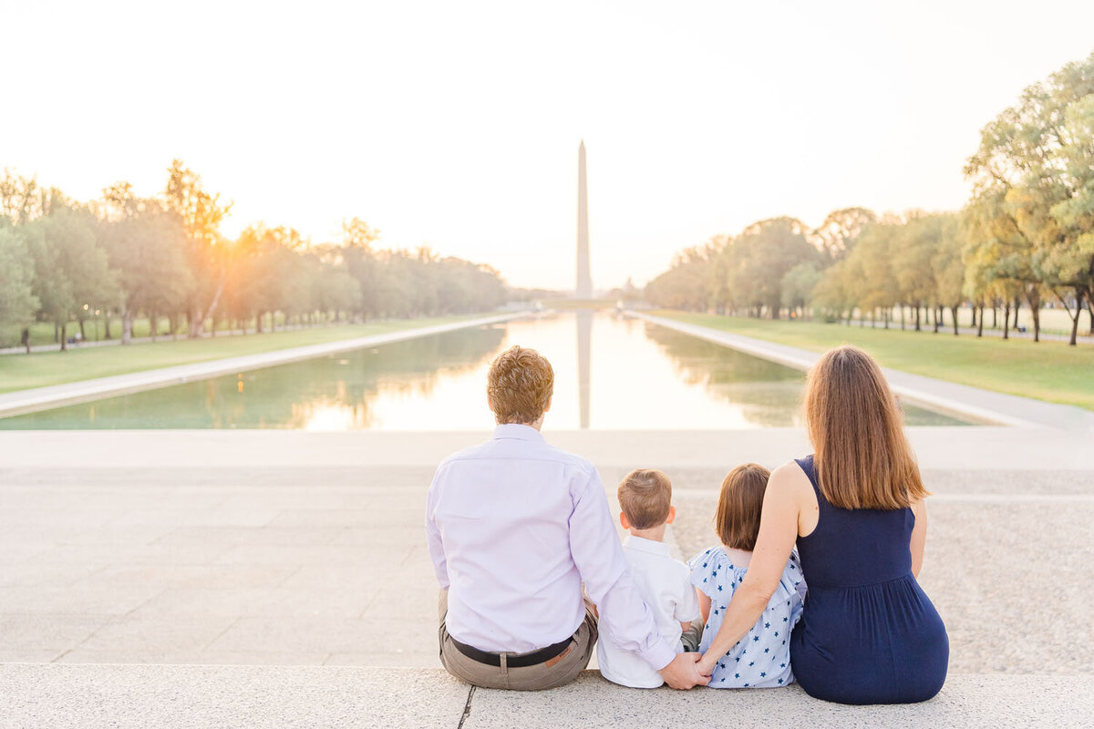 family of 4 looking at the Washington Monument during their Northern VA family photography