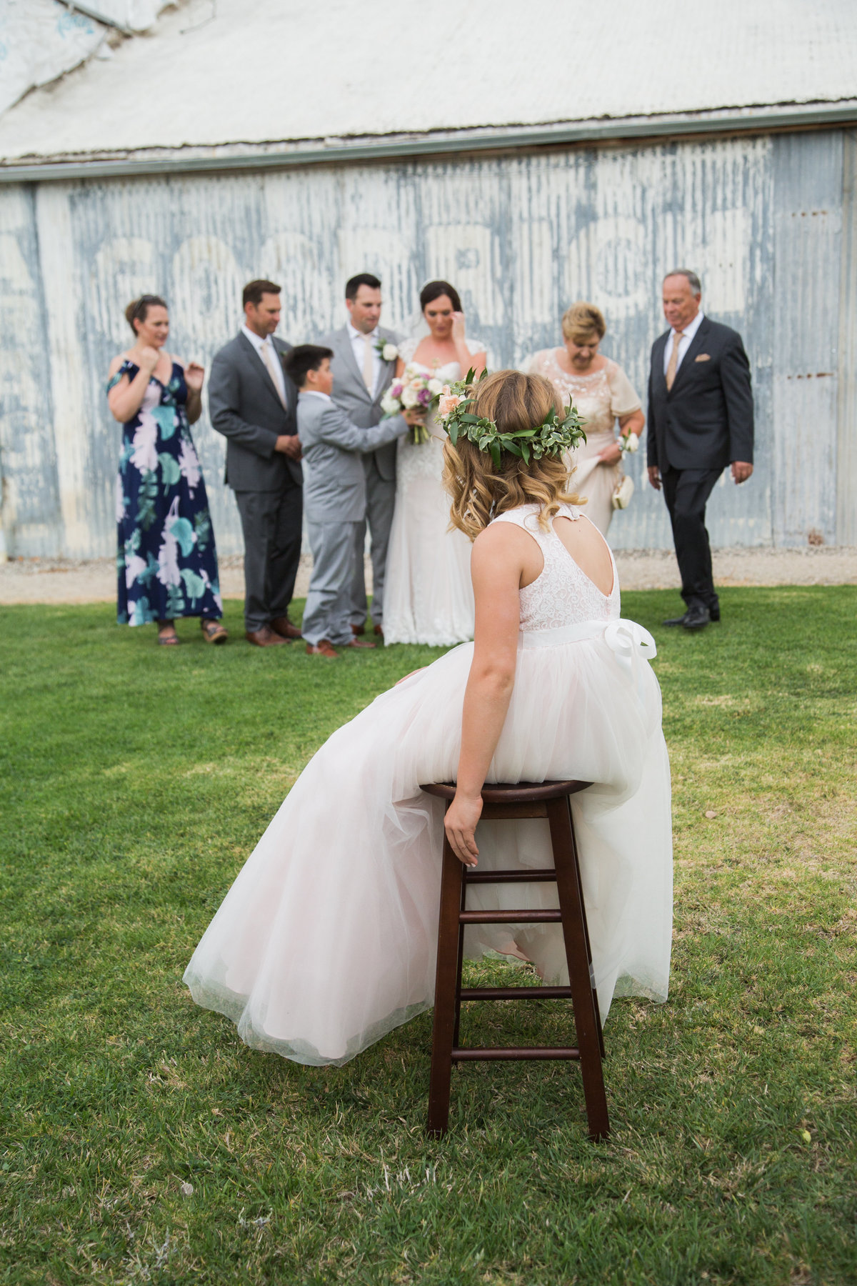Flower girl sits infront of family formal photos at 1880 Union Hotel Wedding