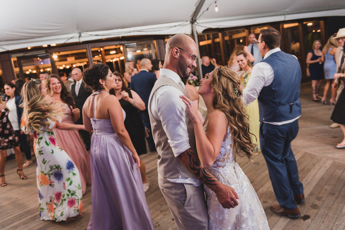 photo of bride and groom dancing with all the guests during wedding reception at Pavilion at Sunken Meadow