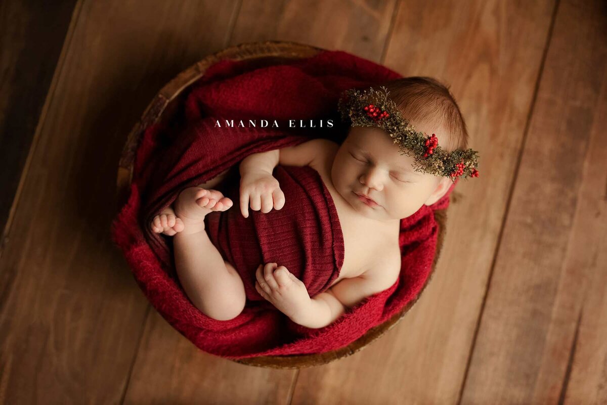 Stunning newborn portrait of baby wrapped in red cloth