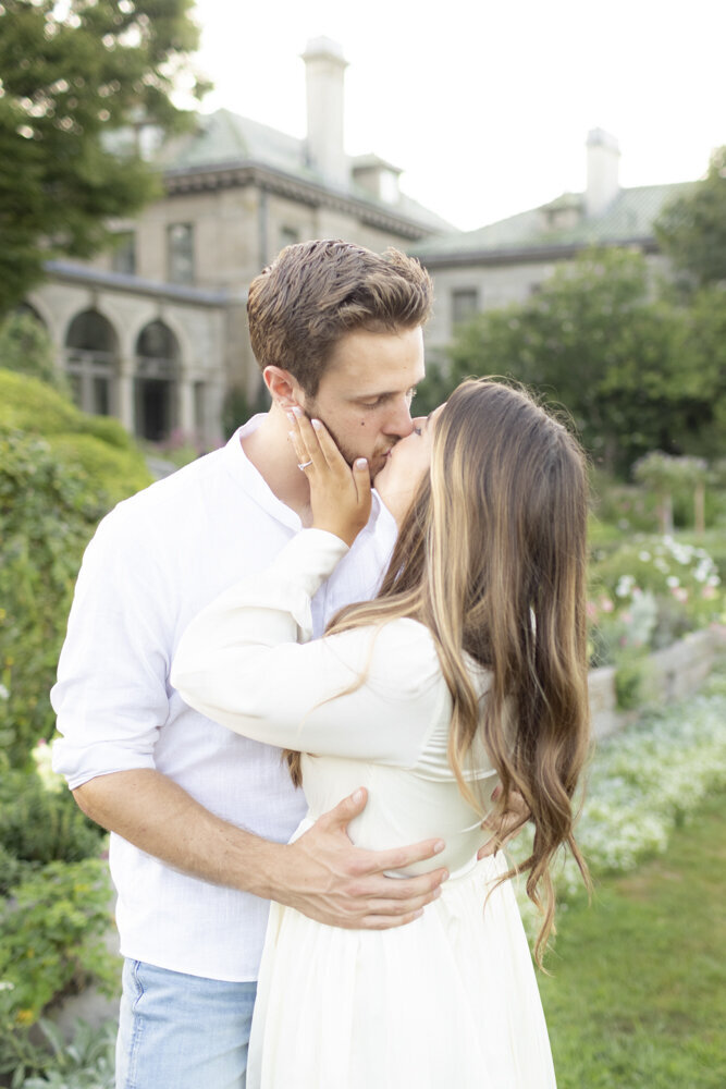 romantic garden engagement photo of couple kissing