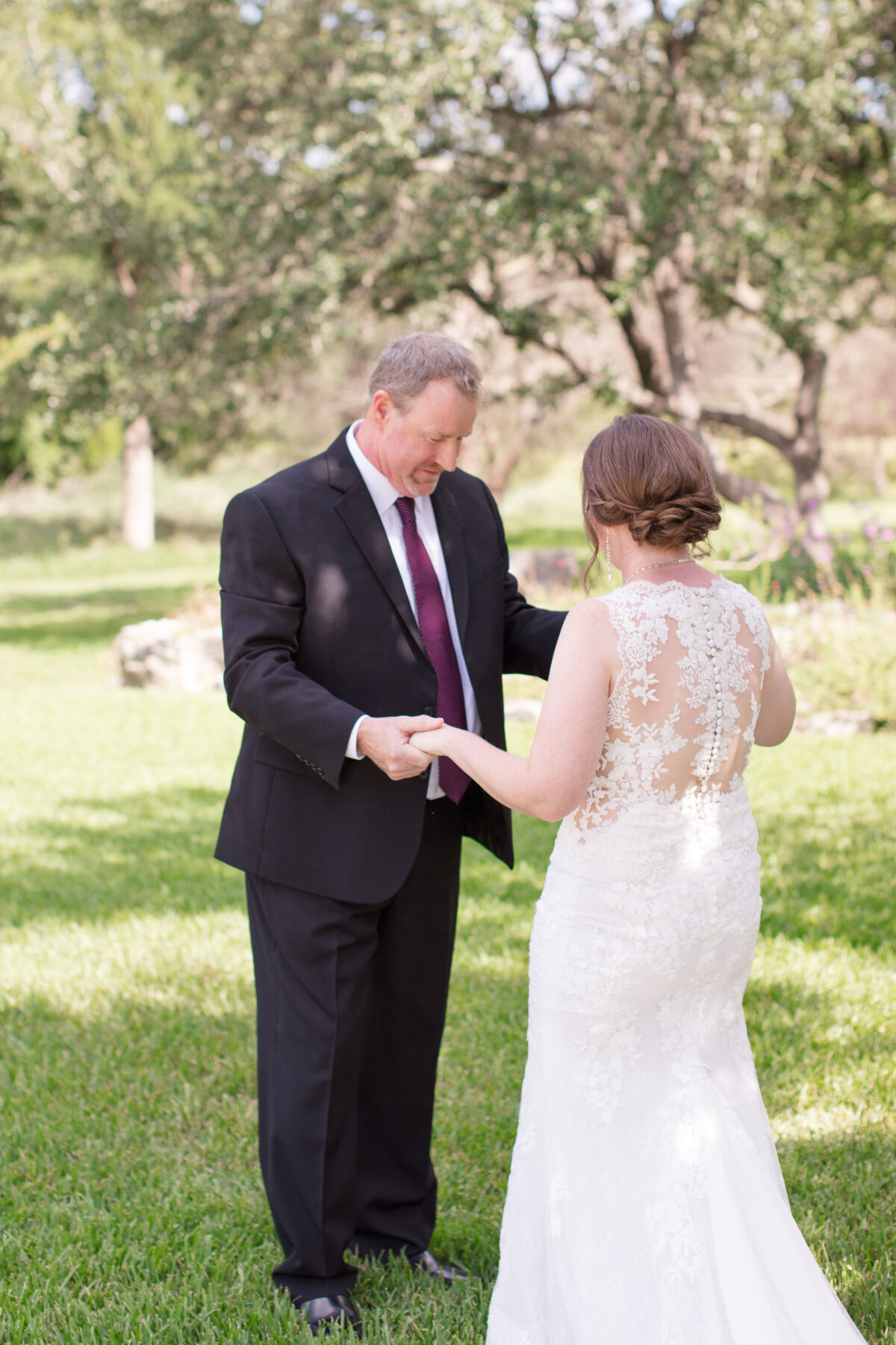 father of the bride takes a good look at his daughter at Milestone New Braunfels wedding in tree shade