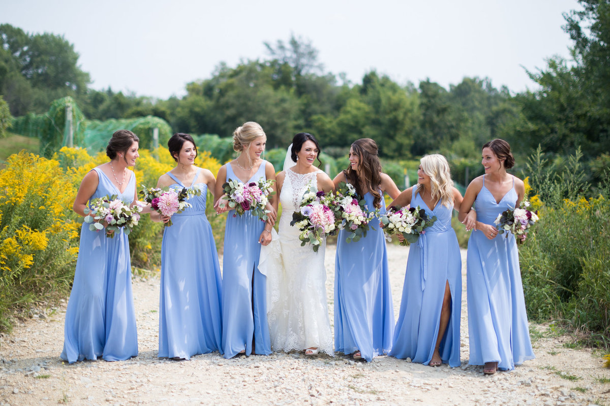 Bridesmaids with the softest shade of blue on a gravel road in the midwest
