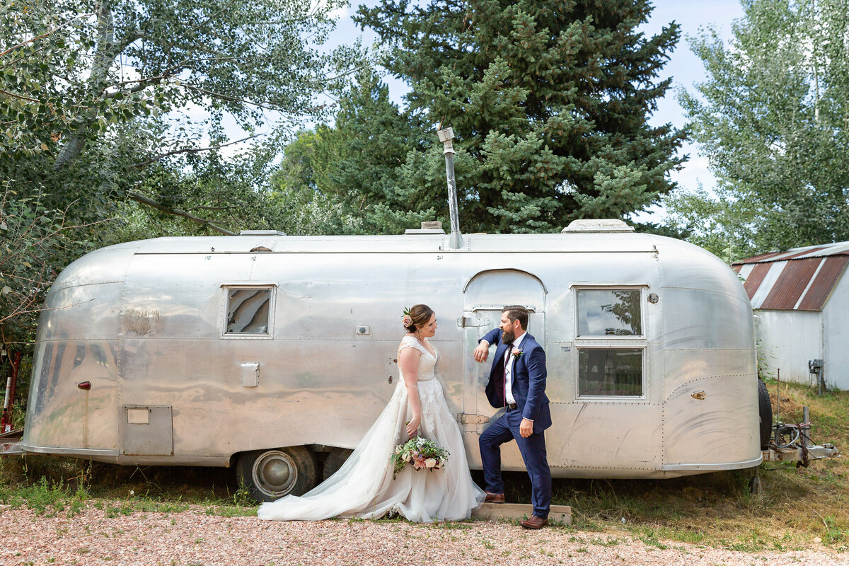 bride & groom with an old Airstream trailer in retro themed wedding
