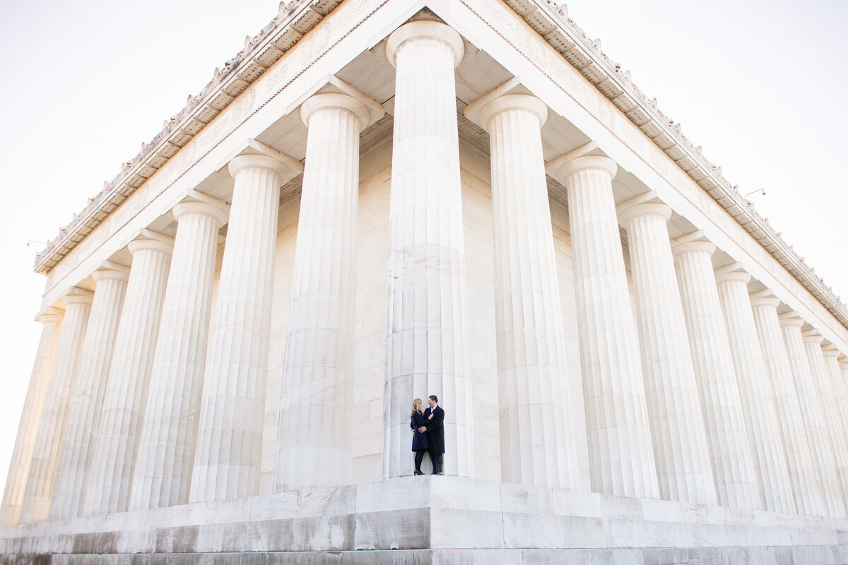 Family session of couple standing in front of a building