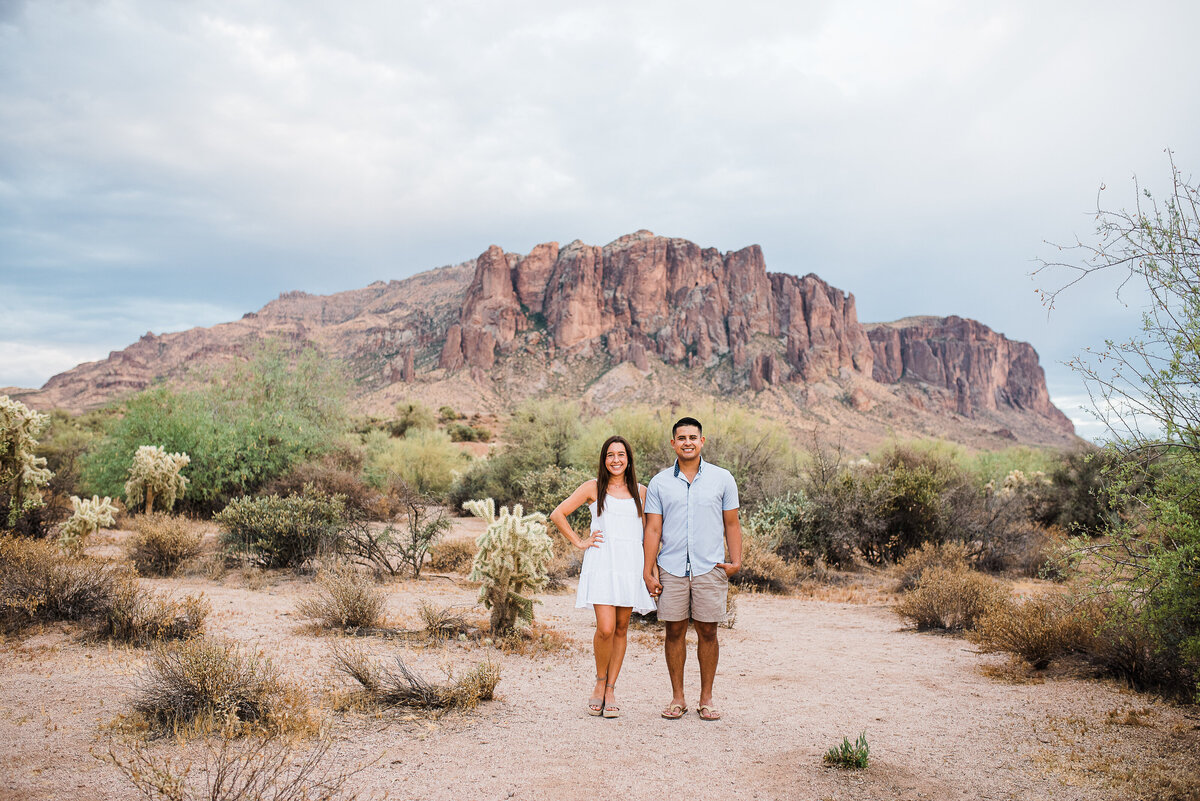 enaggement photos couple posed infront of superstition mountains with storm rolling in