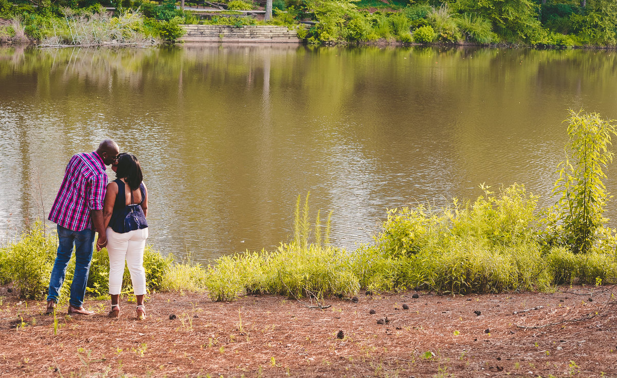 couple kissing by a lake