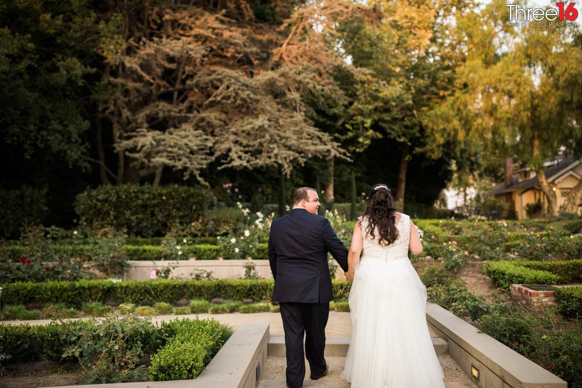 Bride and Groom take a walk holding hands on the grounds of the Richard Nixon Library wedding venue