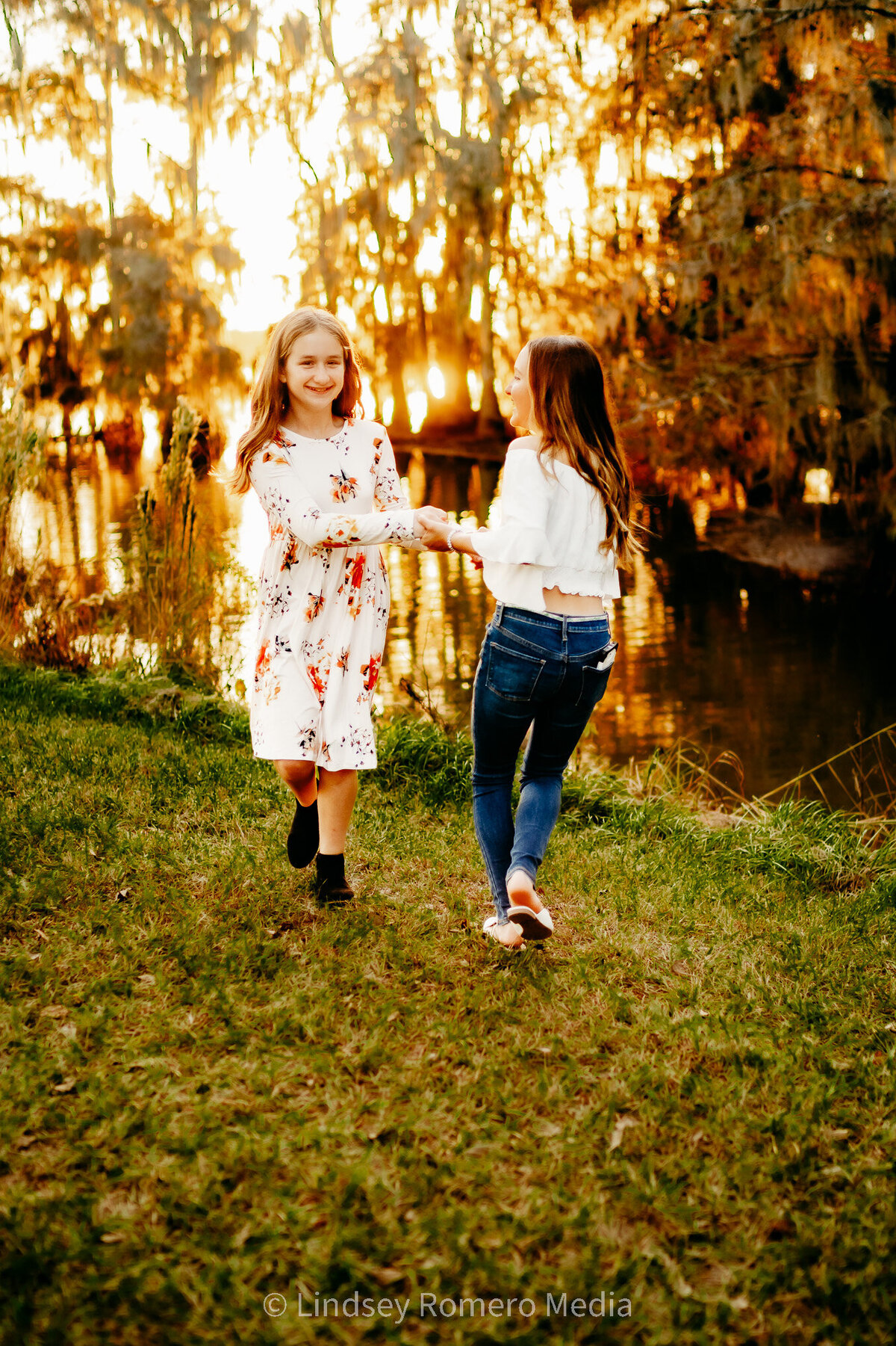 sisters and best friends twirling and dancing at lake martin, la