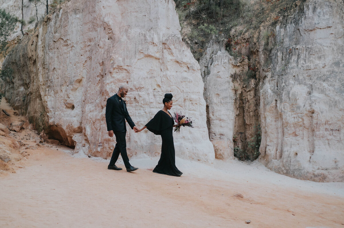 Black couple wearing black outfits walking in the desert