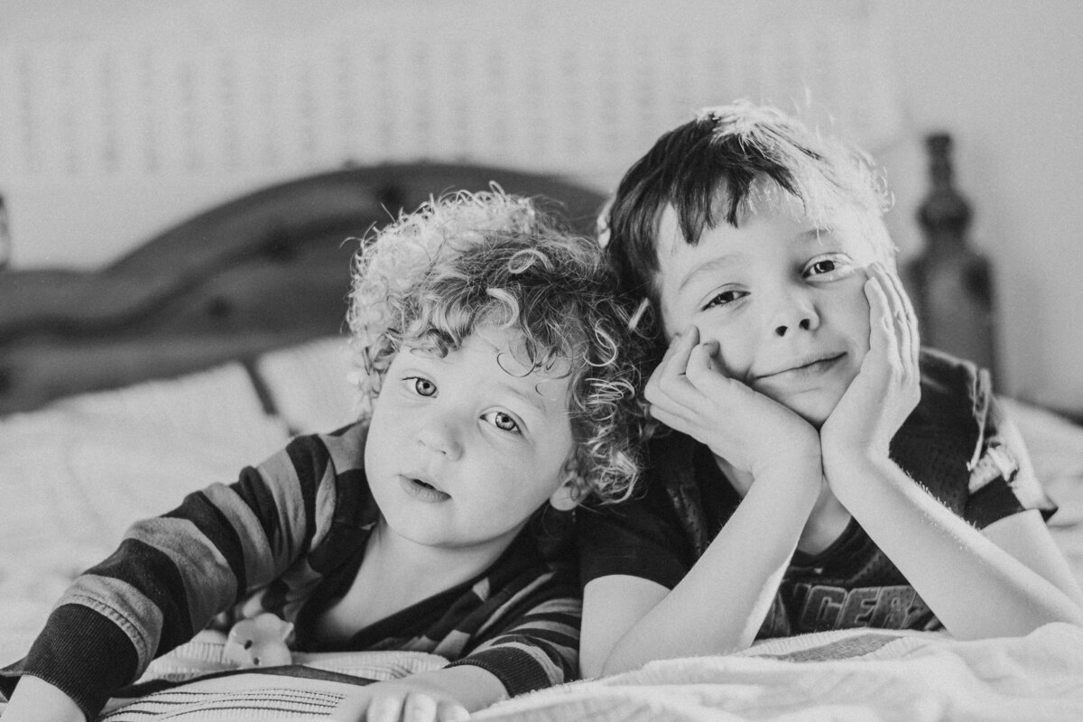 Two boys sitting on a bed during West Sussex family photoshoot