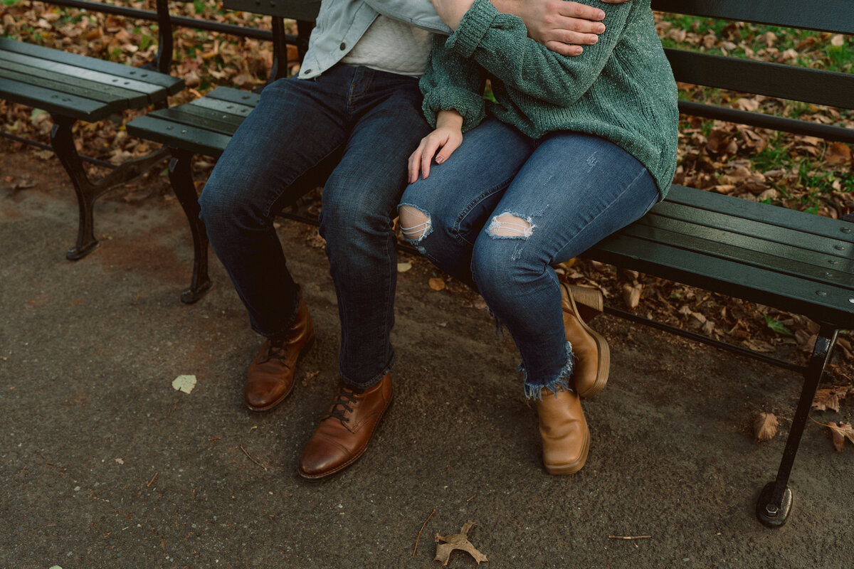 man and woman legs on a park bench