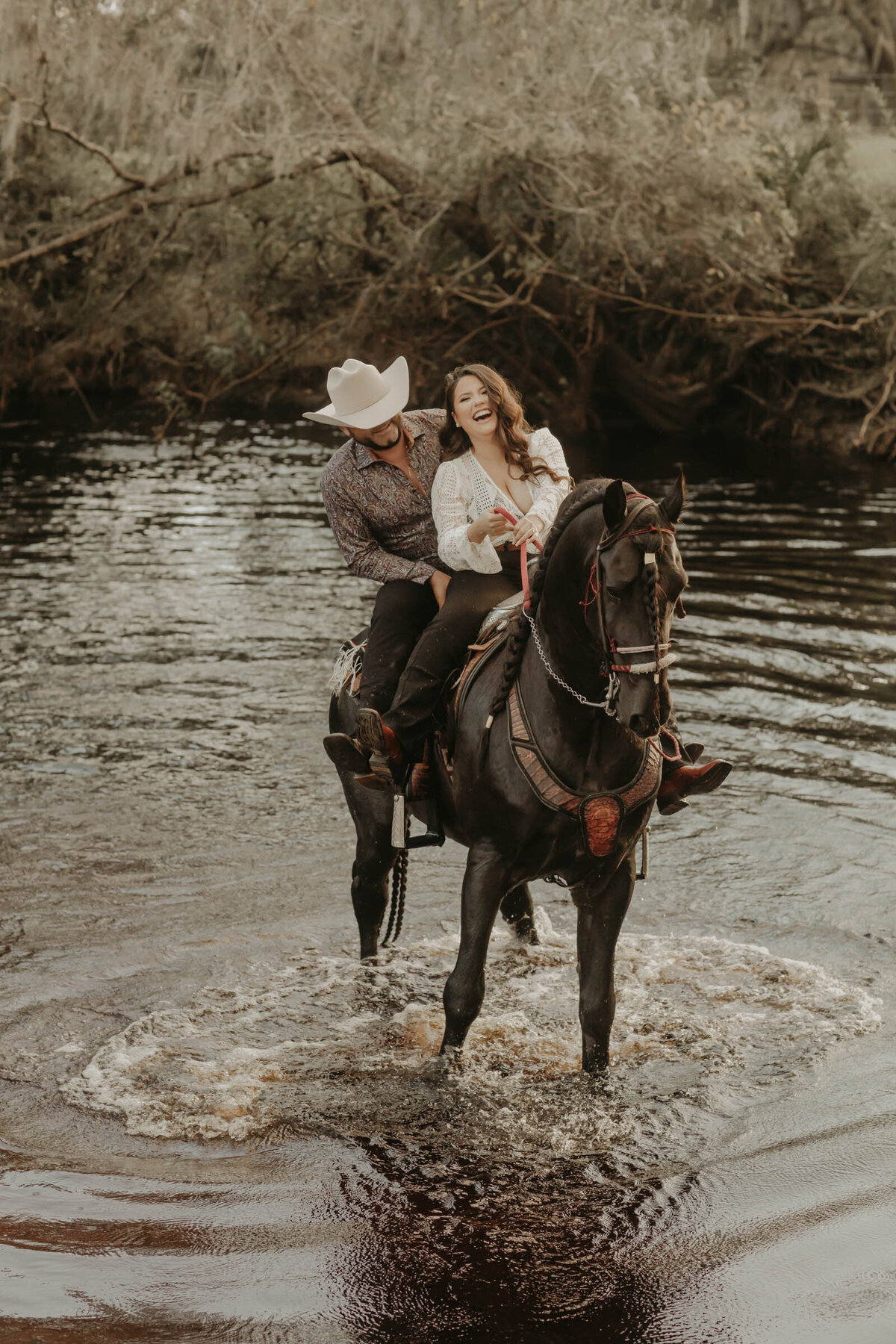 This image is of a couple riding a horse for a portrait.