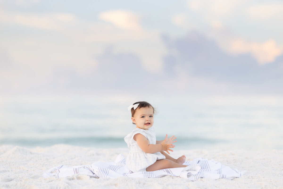 In Watercolor Florida,  baby sitting in the sand at the beach