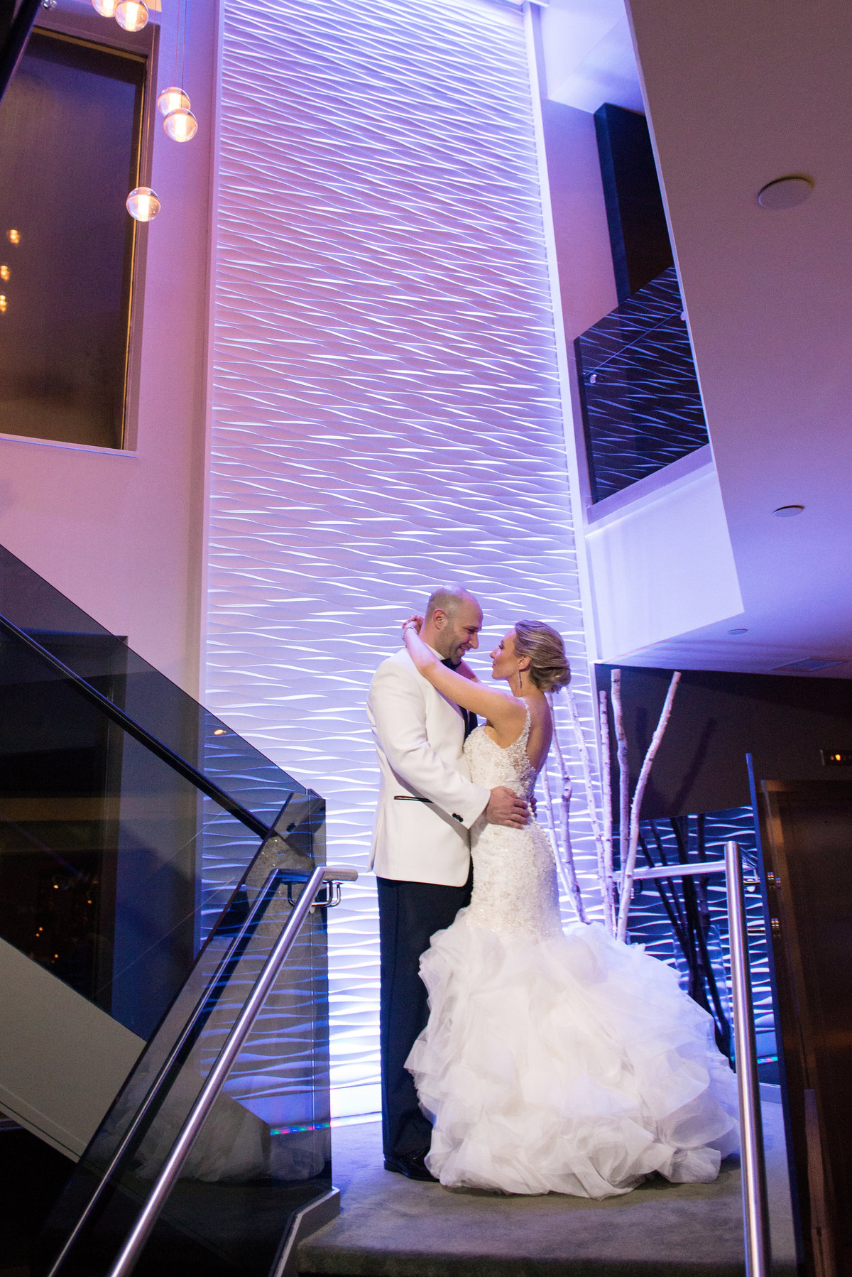 Bride and Groom at the stairs of Harbor Club at Prime with purple uplighting