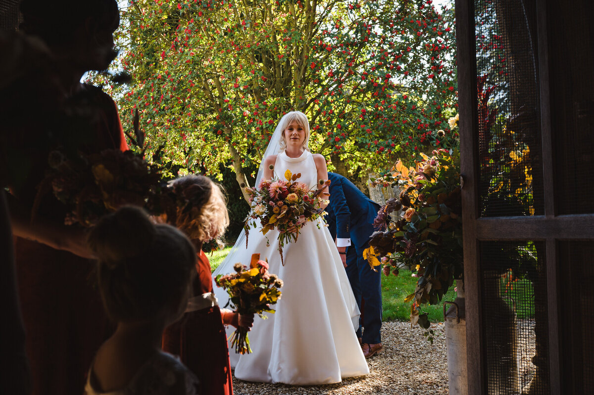 Bride waiting to enter the church with her autumnal bouquet