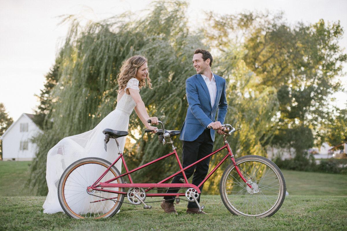 Soft romantic whimsical wedding photo with a bicycle made for two
