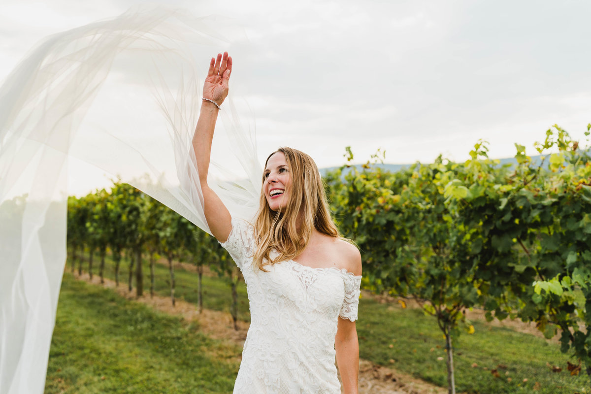 A photo of a bride at Kalero Vineyard tossing her veil in the wind